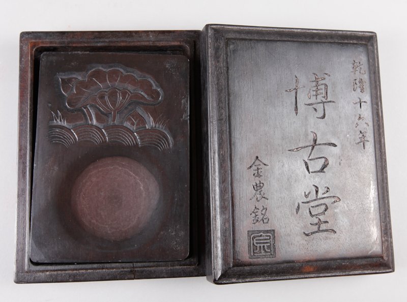CHINESE BI GU TANG INK STONE IN BOX: Lotus design on stone, in custom carved wood box with etched caligraphy and seal mark. Box measures 2" H x 6.5" L x 4.875" W.