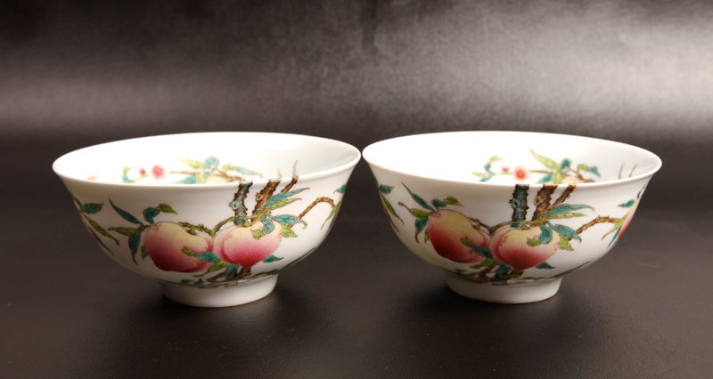 Pair of Chinese Famille Rose Peach Bowls: The interior and exterior finely painted depicting peaches and vines, with iron red bats. Six character Qianlong mark in blue on underside. 3" H x 6.26" Dia. Excellent condition.