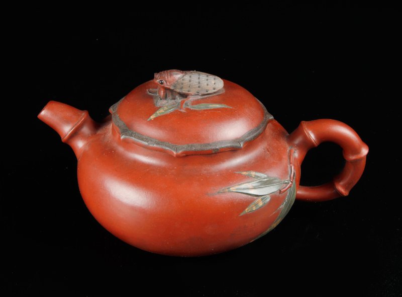Chinese Yixing Clay Tea Pot: Tea pot with bamboo spout and handle with extending leaves, the lid with locust handle. Two character mark within a circle with additional caligraphy mark on underside. 3.75" H x 7.125" L. Excellent c