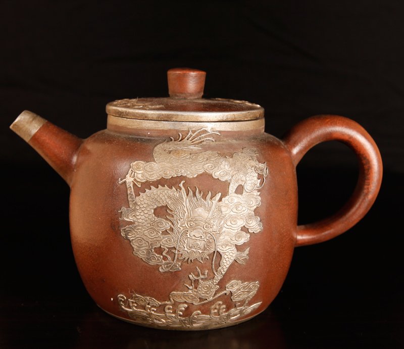 Chinese Zi Sha Tea Pot: With applied metal depicting a dragon to either side. Four character mark on underside. 5.25" H 8" L. Excellent condition.