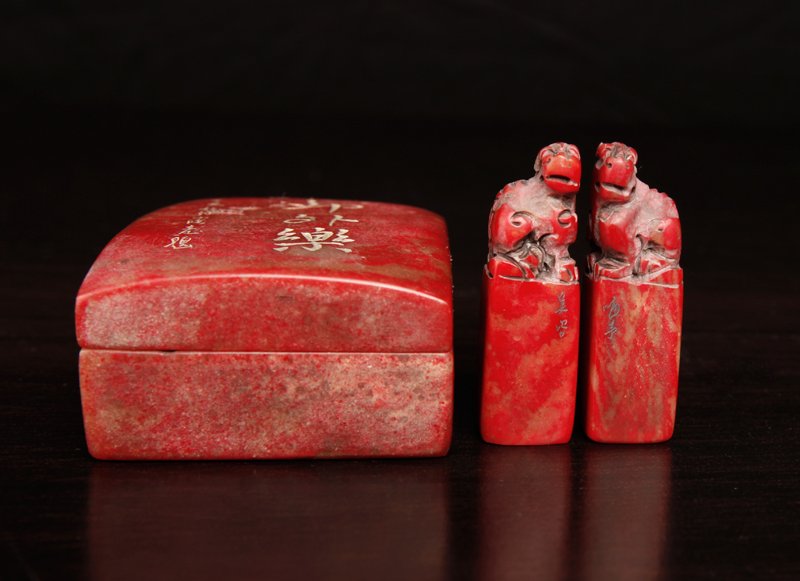 Chinese Chicken Blood Soapstone Seals in Box: Each small seal with two characters, carved at top depicting foo dogs. Housed in custom chicken blood soapstone box with caligraphy on top and four character mark on underside. Tallest seal measures 1