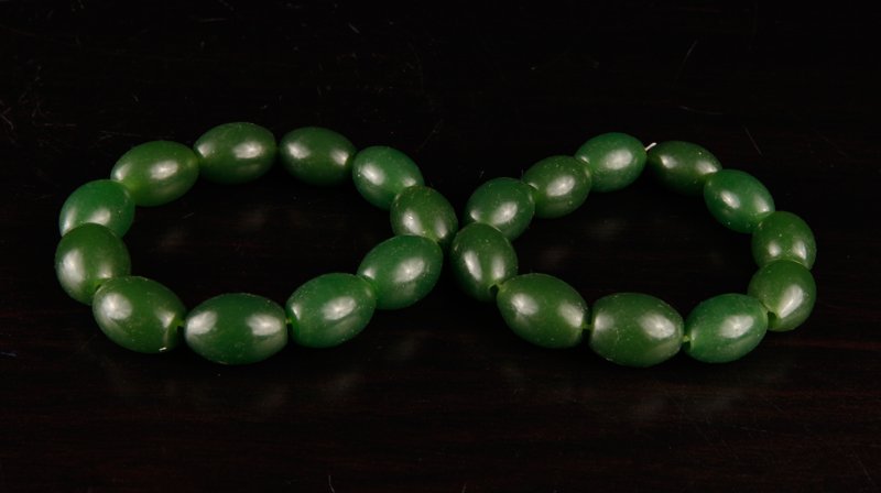 Pair of Chinese Jade Bead Bracelets: Each with eleven uniform beads. Excellent condition.