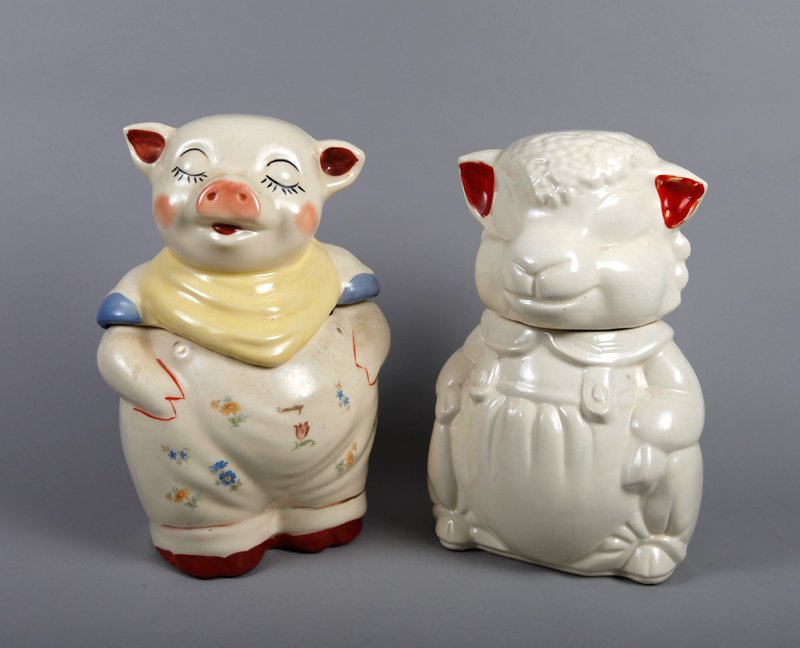 Shawnee Smiley & Apco Cookie Jars: Includes a Shawnee Smiley 1940's pig cookie jar with cursive "Smiley" on overalls (glaze anomole on top and interior chip). Together with an ABCO lamb in overalls cookie jar (crazing to interior). Tal
