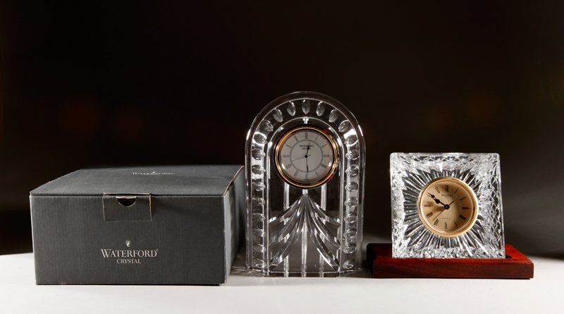 2 Waterford Crystal Mantle Clocks: Includes an Olive clock on mahogany stand, together with a dome form clock. Largest 8.25" H x 5.5" W. Both in excellent condition.