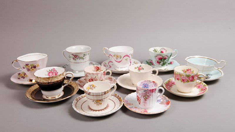 Grouping of Porcelain Tea Cups and Saucers: Includes eleven tea cups with matching saucers, and a porcelain creamer and covered sugar bowl. One plate with repair, and some with minor surface cracks.