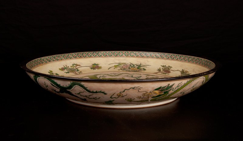 Chinese Famille Rose Porcelain Basin: The interior with two dragons and flaming pearl, with floral designs to outside, the exterior with dragons and flaming pearls. Six character Kangxi mark in blue on underside. 2.875" H x 17.25" Dia. Ex