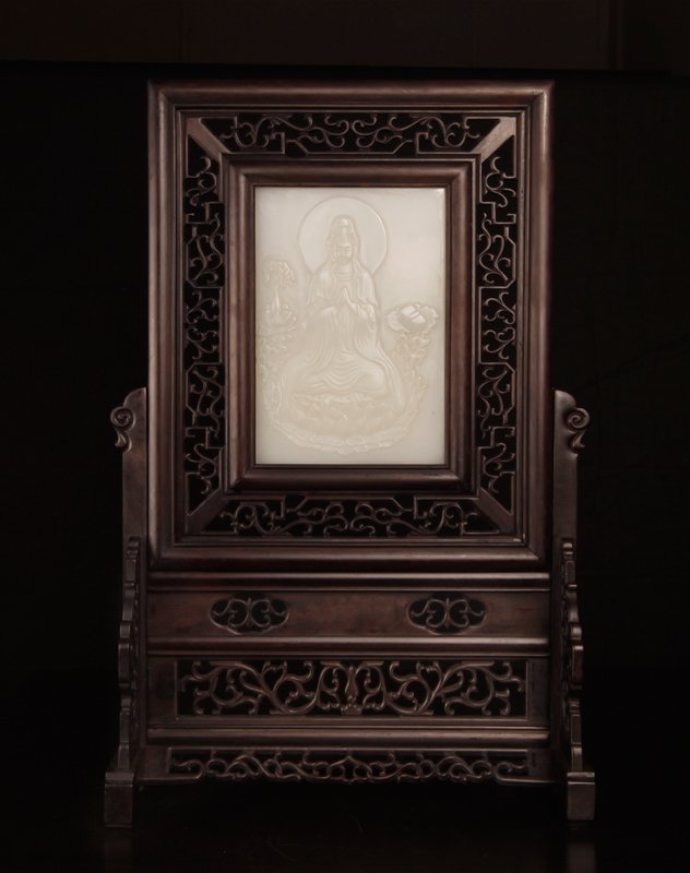 Chinese Jade & Zitan Wood Table Screen: In carved hardwood openwork frame, the jade carved on one side depicting a seated Guan Yin, the reverse with lines of caligraphy. 16.5" H x 10.625" W x 4.75" D. Overall in excellent condition, screen 