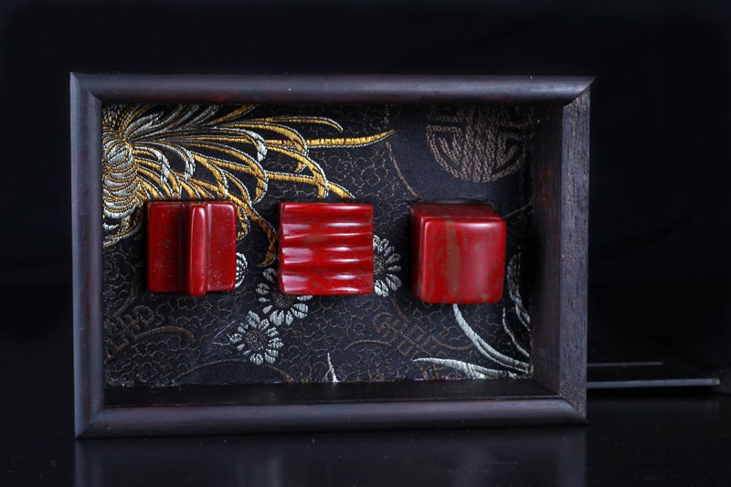 3 Chinese Chicken Blood Seals in Wood Box: Each four character seals, the tops carved with handle, ribbing and plain. In custom fitted carved wood box. Largest seal measures 1.25" H x 1" Sq. Excellent condition.