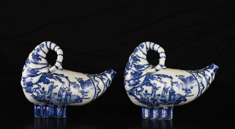 Pair of Chinese Blue & White Teapots: Cornicopia shape with figures in an exterior setting to one side, and figure on a dragon on other side. Six character mark in blue on backside. 6" H x 7.25" L x 3" W. Excellent condition.
