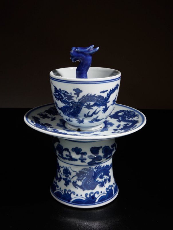 Chinese Porcelain Planter: Two piece, with the cup with central dragon figure and holes to underside, the base with dragon designs and holes below cup. Six character mark within two circles in blue on underside. 8.5" H x 6.5" D
