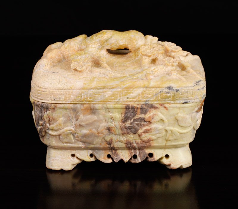 Chinese Republic Carved Soapstone Box: Covered box, the top carved with prunus, branches and Greek key design around edge, the box carved with floral designs. 3.75" H x 4.5" L x 3.5" W. Natural cracks and inclusions.