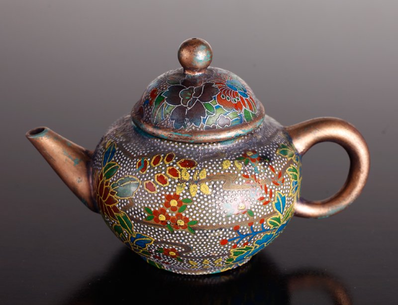 Chinese Enameled Zisha Clay Teapot: Decorated with multi-color floral and peony designs. Gilded handle, spout and top of lid, the remainder with gilt highlights. Four character mark to underside. 3.75" H x 5.5" L. Some chipping to inter