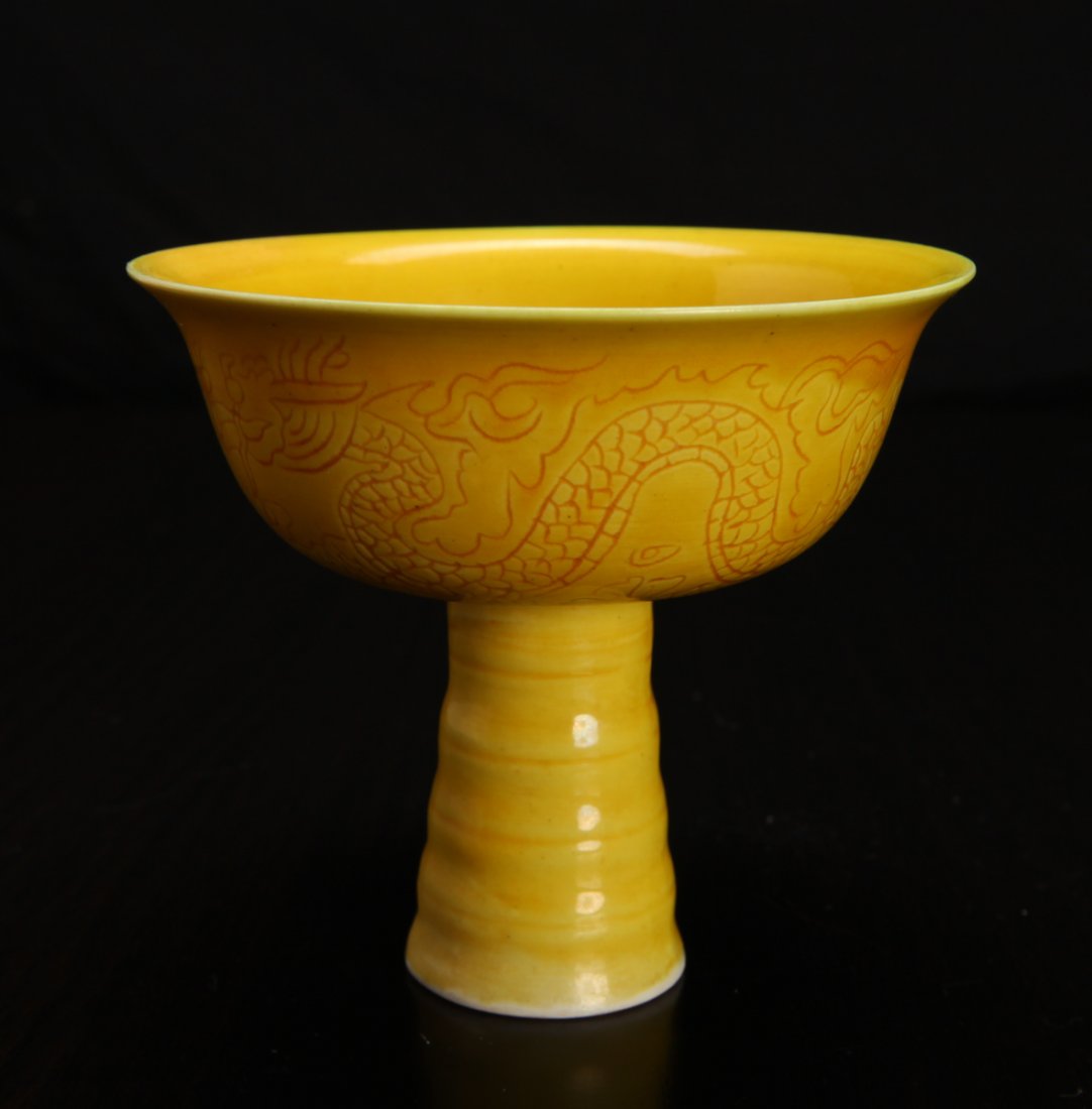 Chinese Incised Porcelain Wine Cup: Interior and exterior in saffron glaze, with floral design to interior, the exterior with dragon and Phoenix. Six character mark in black or blue to underside. 3.375" H x 3.75" W. Excellent condition.