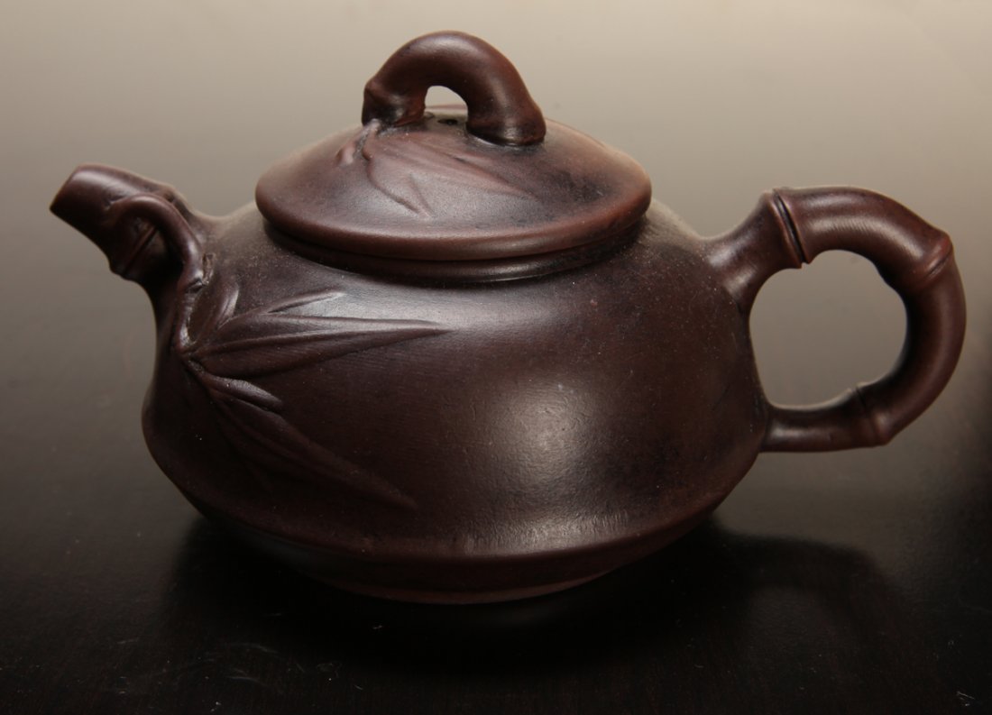Chinese Zisha Clay Teapot: Bamboo handle and spout, with bamboo leaves on lid and body. Two character mark on underside. 3" H x 5.5" L. Excellent condition.