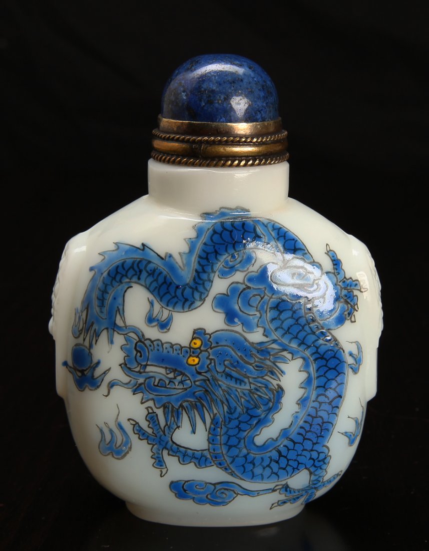 Chinese Peking Glass Snuff Bottle: White glass, enameled in blue on both sides depicting a Phoenix and a dragon, with blue lapis stone lid. Three character mark in red on underside. 3.5" H x 2.375" W. Excellent condition.