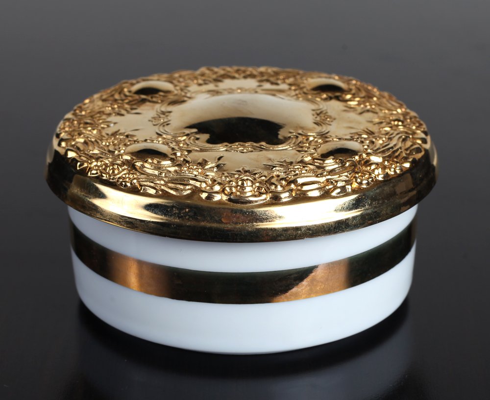 24K Gold & Porcelain The Art of Chokin Trinket Box: White porcelain box with gold banding, the lid with repousse of cartouche and floral and scrolling designs. Box measures 1.875" H x 4" Dia. Excellent condition with slight wear to banded side. Please 