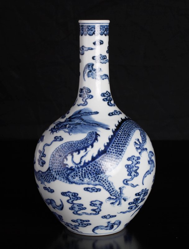 Chinese Porcelain Vase: In blue and white depicting a dragon amid ruyi clouds and bats. Six character mark in blue on underside. 8.5" H x 4.5" W. Excellent condition.