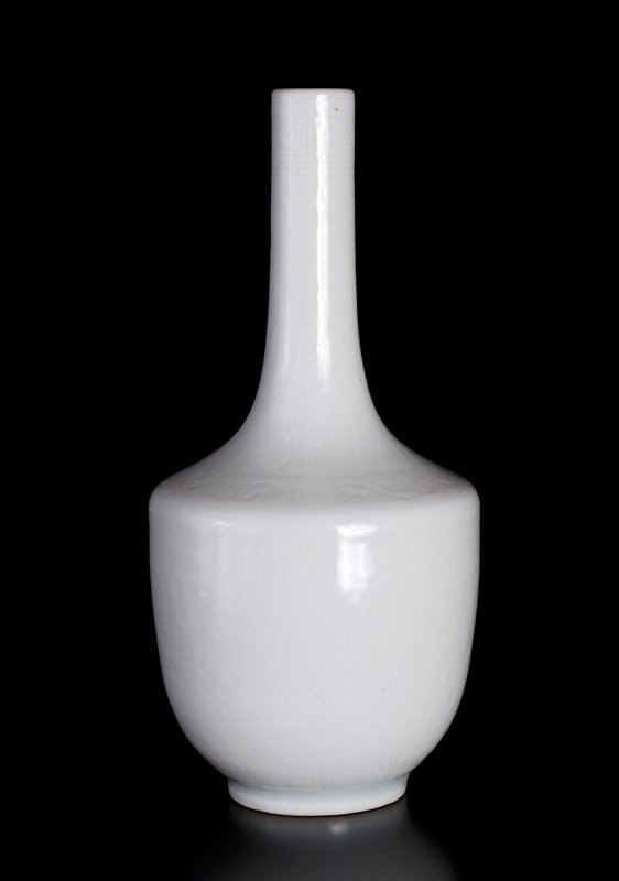 Chinese Incised Porcelain Vase: Incised with dragons, glazed in white. Six character mark within two concentric circles in blue on underside. 6.625" H x 3" W. Excellent condition.