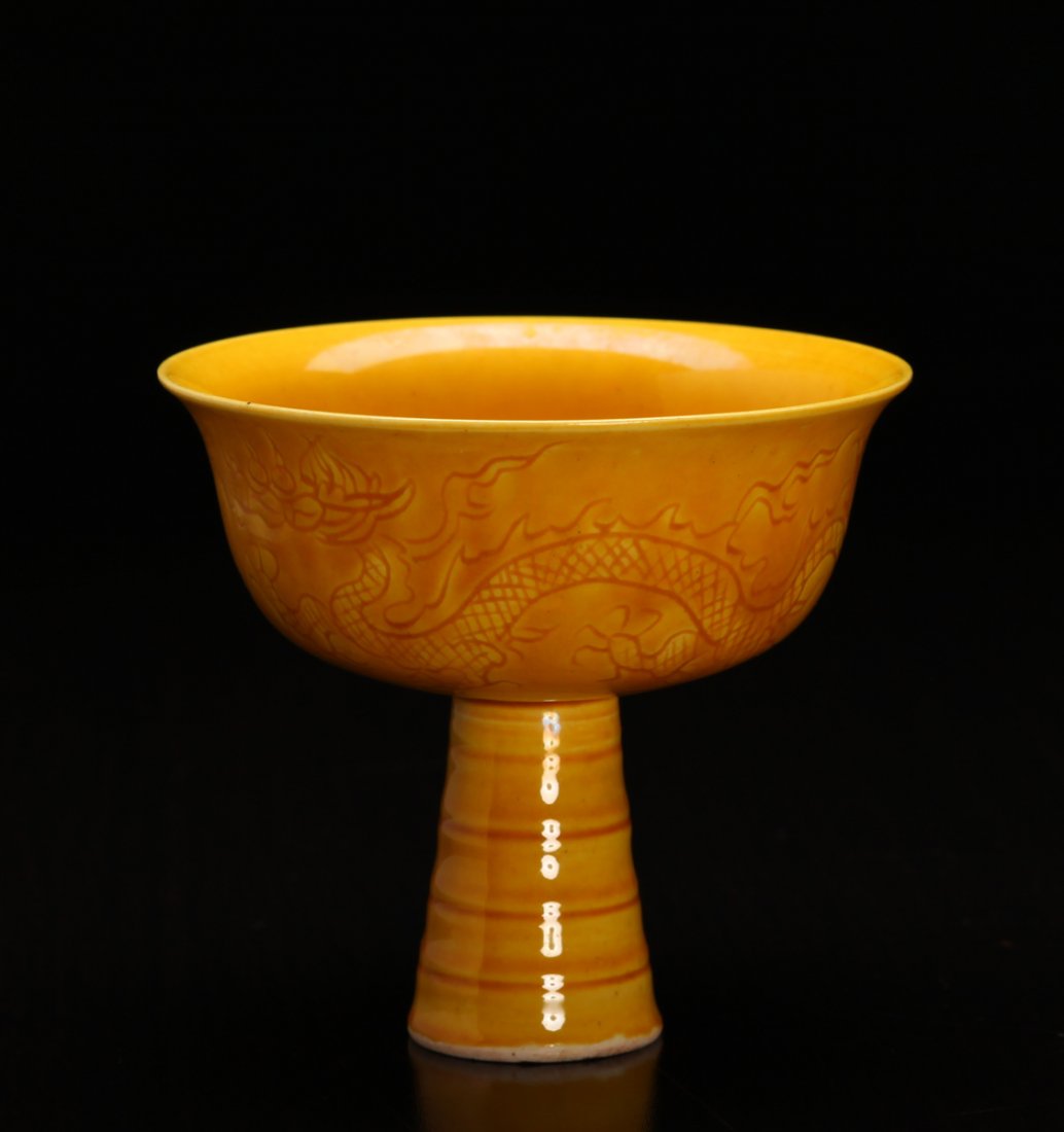Chinese Incised Porcelain Wine Cup: Interior and exterior in saffron glaze, the exterior with dragon and Phoenix. Six character mark in black or blue to underside. 3.5" H x 3.875" W. Excellent condition.