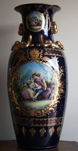 Lg. Ornate porcelain vase: Lg.Ornate blue porcelain vase measuring approx. 32h x 15w x15d containing mural and gold reliefs in very good condition.