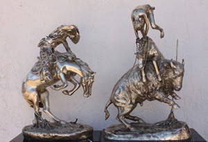 Pair of Remington bronze sculptures: One pair of western bronze sculptures after Frederic Remington titled "Buffalo Horse" measuring approx. 26x18.5x11 and "Rattlesnake" measuring approx. 22.5x16x9.5 in good condition.