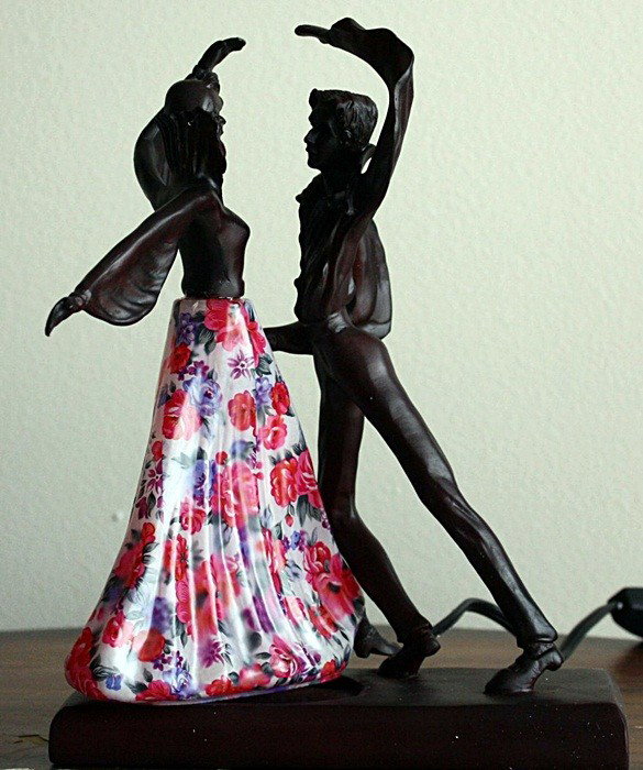 "The Dance" sculpture lamp: "The Dance" sculpture lamp measuring approx.10hx8w x 4.5d. The lamp is in perfect working condition with a ornate glass shade dress lighting up. Very good condition.