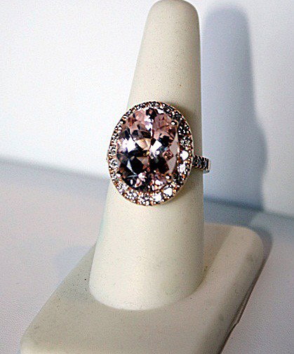 Ladies 14K Rose Gold Morganite and Diamond Ring: Ladies 14K rose gold ring mounted with one 7.76ct oval mixed cut natural Morganite and 30 bead set round brilliant cut diamonds. The ring weighs a total of 6.48g . The Morganite measures 15.70 x 11.5 