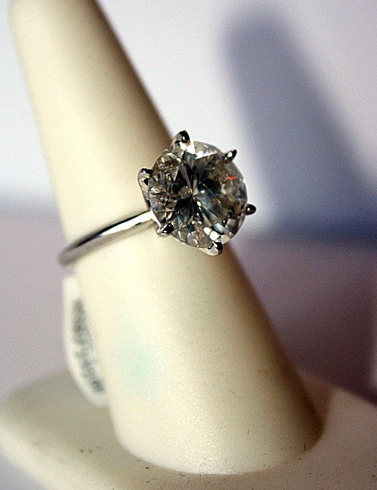 Ladies 6ct Diamond Solitaire: Ladies 14K white gold ring mounted with one genuine 6ct Round Brilliant cut diamond. The ring weighs a total of 4.00g and fits a finger size 6.75. The setting measures 13.60 x 11.78 mm. The diamonds c
