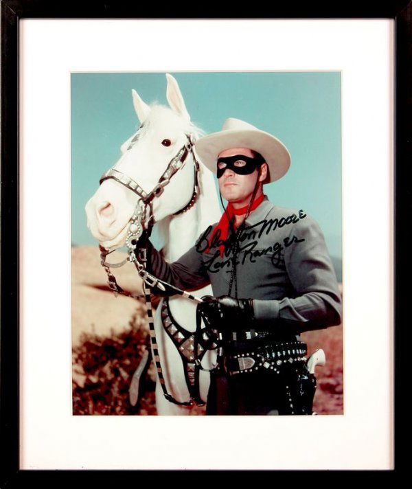 CLAYTON MOORE SIGNED PHOTOGRAPH: 1041. CLAYTON MOORE (1908-1999). Tall leading man of '40s second features, later famous as television's Lone Ranger. SP, color, 8"x10" standing portrait with his stallion Silver. Darkly signed in blac