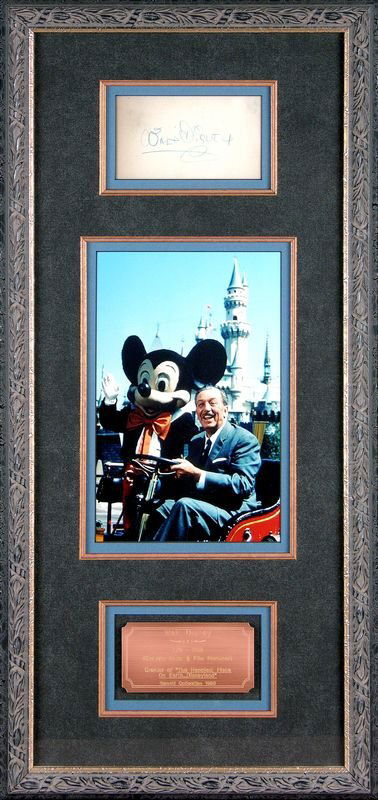WALT DISNEY SIGNED CARD W/PHOTO DISPLAY: 549. WALT DISNEY Bold signature on card in blue crayon, 4½"x2½", handsomely matted in suede above photo still of the smiling Disney at the wheel of a golf cart beside Mickey Mouse in