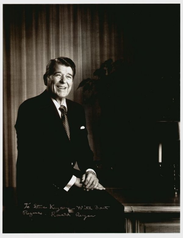 RONALD REAGAN SIGNED PHOTOGRAPH: 687. RONALD REAGAN Printed ISP, b/w, 10¾"x14" three-quarter length seated portrait removed from book. Inscribed and signed at bottom image in silver felt tip. Autograph obtained after he left office.