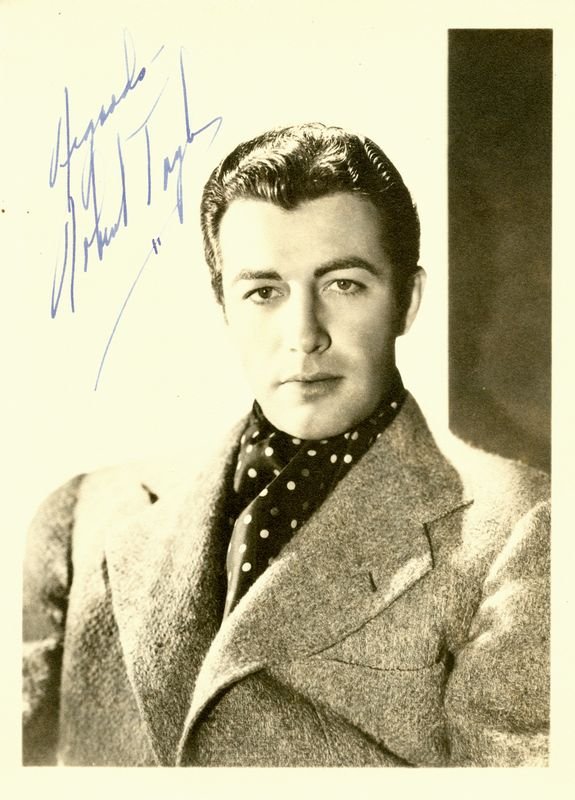 VINTAGE ROBERT TAYLOR SIGNED PHOTO: 884. ROBERT TAYLOR (1911-1969). Handsome leading man best remembered for is performances in Camille, Quo Vadis and Ivanhoe. Vintage SP, b/w matte, 5"x7" quarter-length portrait of the young matinée i