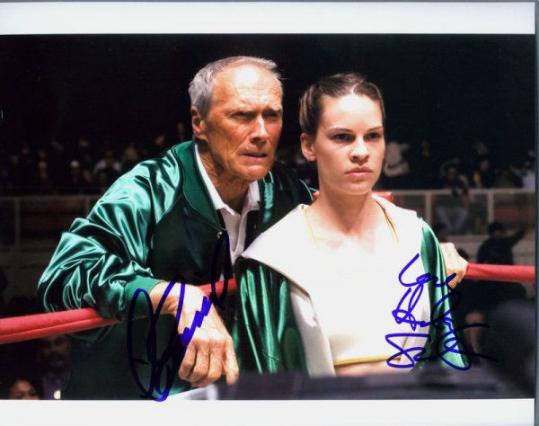 CLINT EASTWOOD & HILLARY SWANK SIGNED FILM PHOTO: 934. CLINT EASTWOOD (b. 1930). Rugged leading man with a cynical, tough-guy image succeeding in television and films before going on to produce and direct. SP, color, film still in a scene with costar