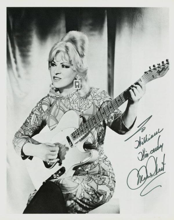 MAE WEST SIGNED PHOTOGRAPH: 1080. MAE WEST ISP, b/w, 8"x10" three-quarter-length seated portrait with guitar. Boldly inscribed and signed with sentiment. Fine. Est: $80-160 Presented by Signature House
