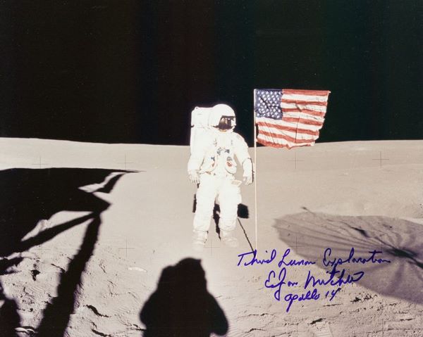 EDGAR MITCHELL SIGNED PHOTO: 452. EDGAR MITCHELL (b. 1930). Apollo 14 lunar module pilot and Moonwalker. Striking SP, color, 10"x8" portrait of the astronaut on the lunar surface beside an American flag. Signed in blue felt tip,