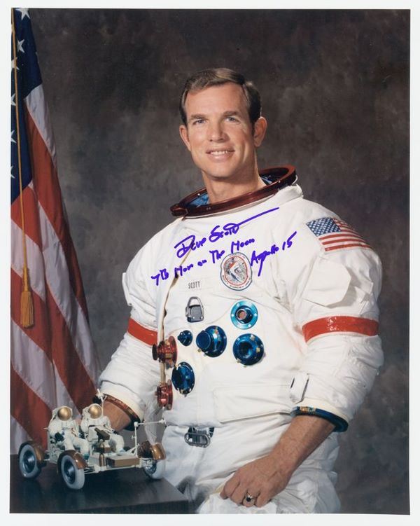 DAVE SCOTT SIGNED PHOTO: 454. DAVE SCOTT SP, color, 8"x10" half-length portrait in an Apollo space suit with a model of the space buggy at his right hand. Boldly signed in blue felt tip, "Dave Scott 7th Man on the Moon Apollo