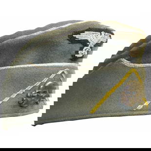 [WAFFEN SS CAVALRY CAP]: Gray overseas cap worn by an SS cavalry officer. The front center above flap displays a 1934 pattern machine woven Nazi eagle with swastika in silver bullion. A patinaed Totenkopf (death head skull) i