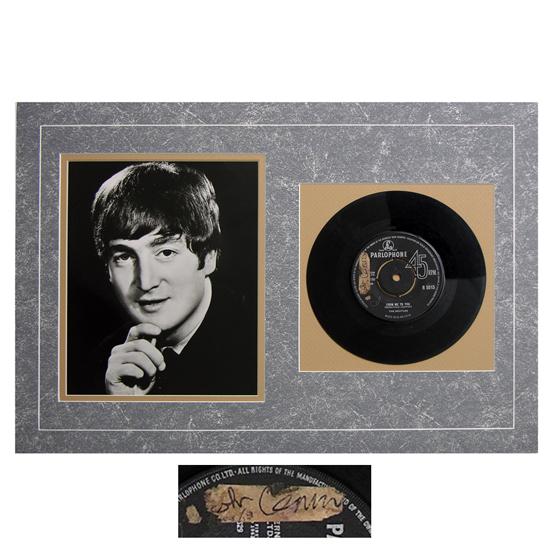 JOHN LENNON: A boldly signed closely cut paper fragment, 1½"x½", affixed to a Parlophone 45 RPM record of Beatles single "From Me To You." Darkly penned. The first initial worn away. Attractively matted with a b