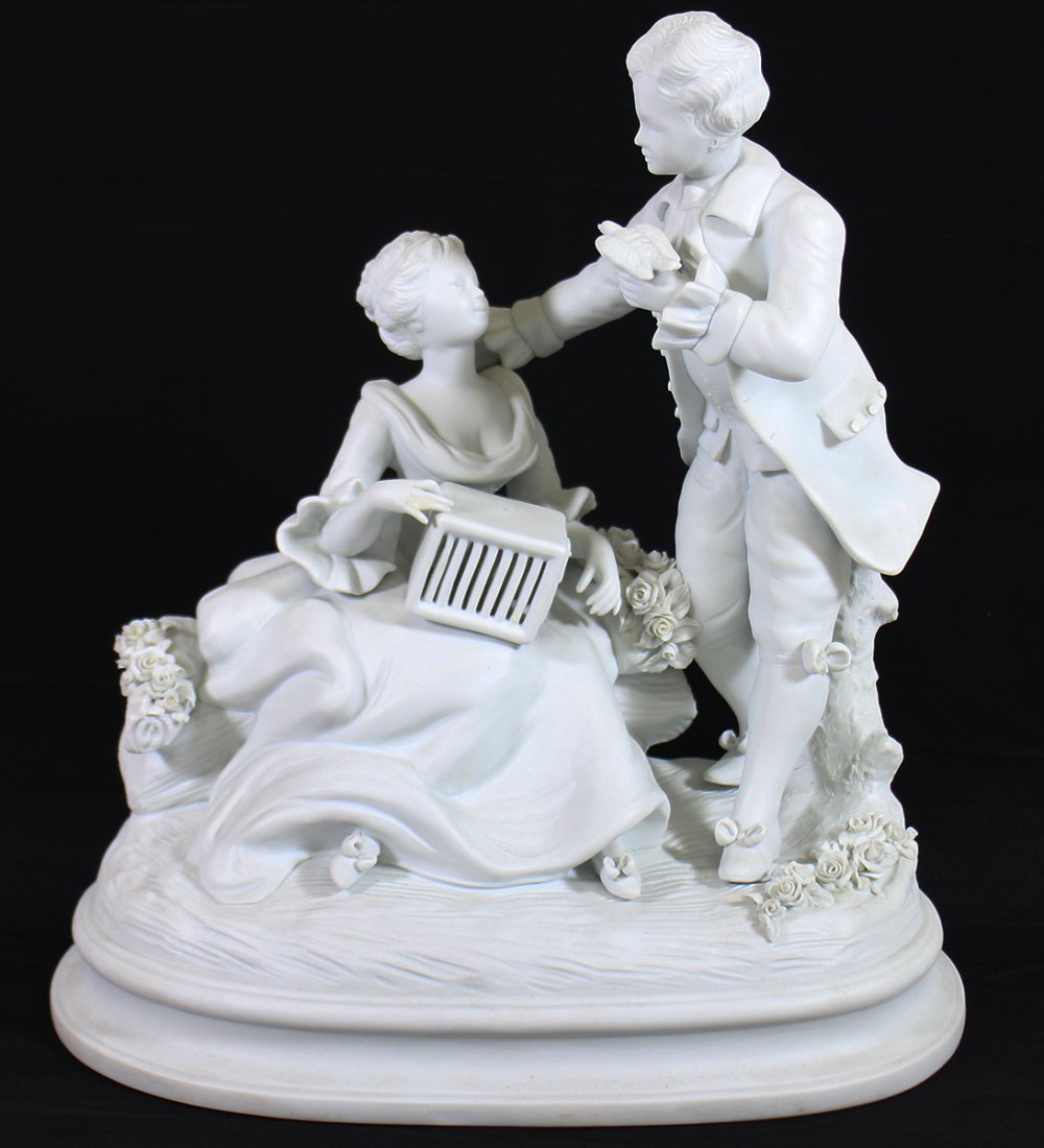 BOUCHER BISQUE STATUE: White bisque statue of a courting scene, young boy giving bird to girl holding birdcage. Signed Boucher on back. 13" wide 14" tall.