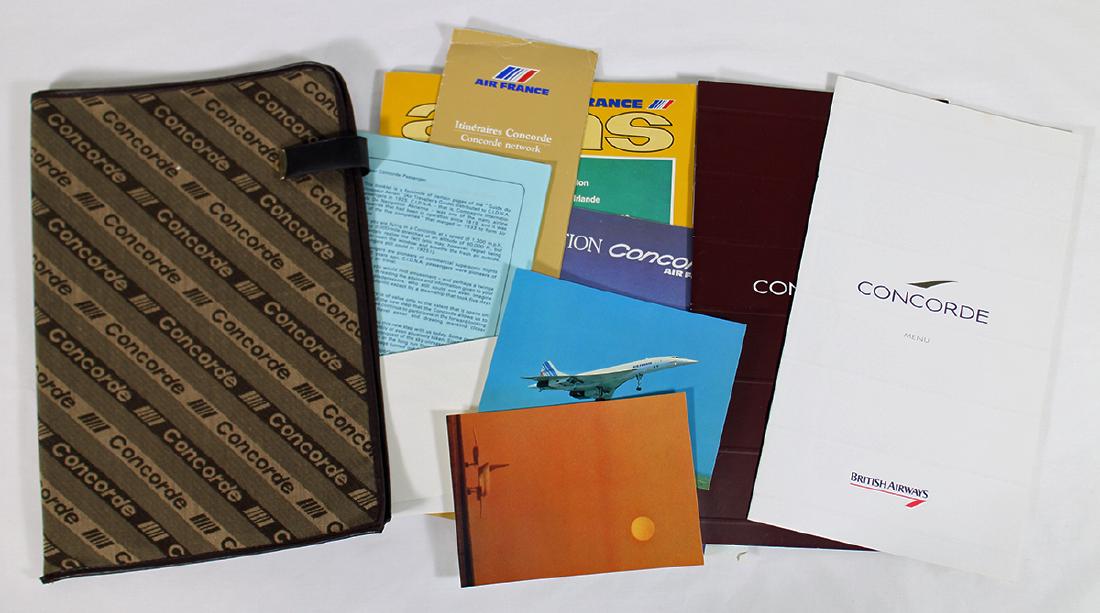 CONCORDE BRITISH AIRWAYS MEMORABILIA FOLDER: Vintage Concorde British Airways Air France cloth packet given to first class passengers. Includes a menu, Instructional booklet, Wine List, Atlas in a Concorde cloth portfolio.