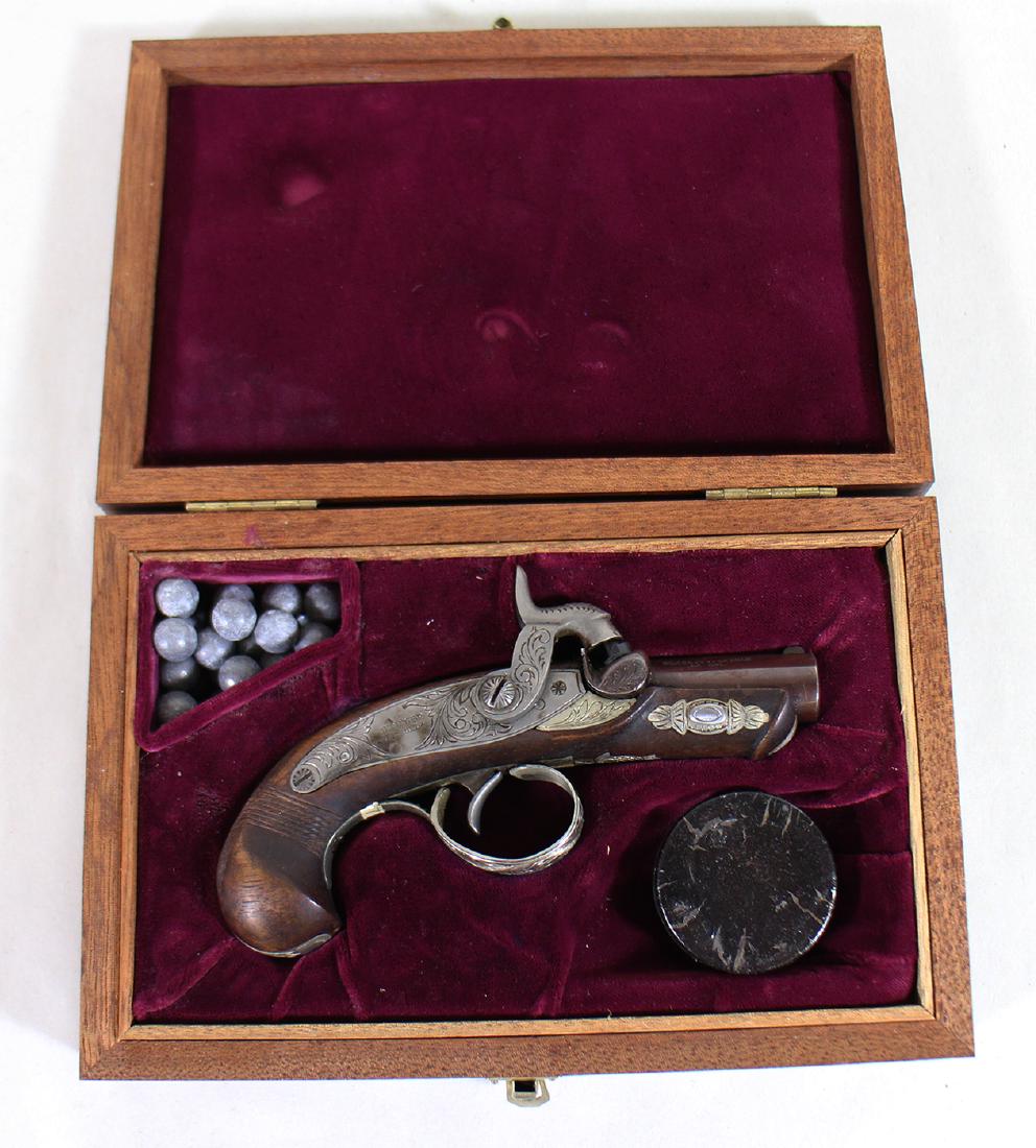 PALMETTO ARMORY PERCUSSION BLACK POWDER DERINGER: Percussion Philadelphia derringer. .41 caliber black powder gun. Hand engraved hardware with German silver inlay. 2" barrel overall 5 1/4". Checkered grip. Comes with wooden box. Marked Deringer Phila