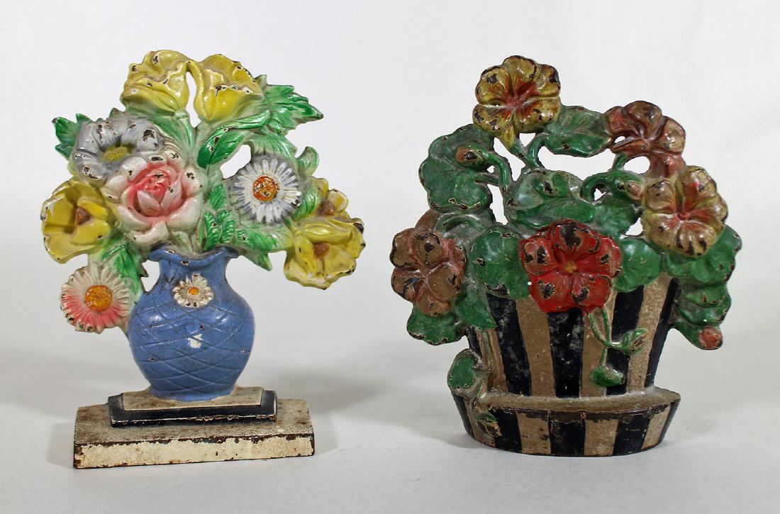 (2) ANTIQUE CAST IRON DOORSTOPS - NASTURTIUMS: A cast iron doorstop basket of nasturtium flowers, possibly Hubley and an assortment of flowers in a vase cast iron doorstop marked 491. They measure approximately 7 1/2" tall.