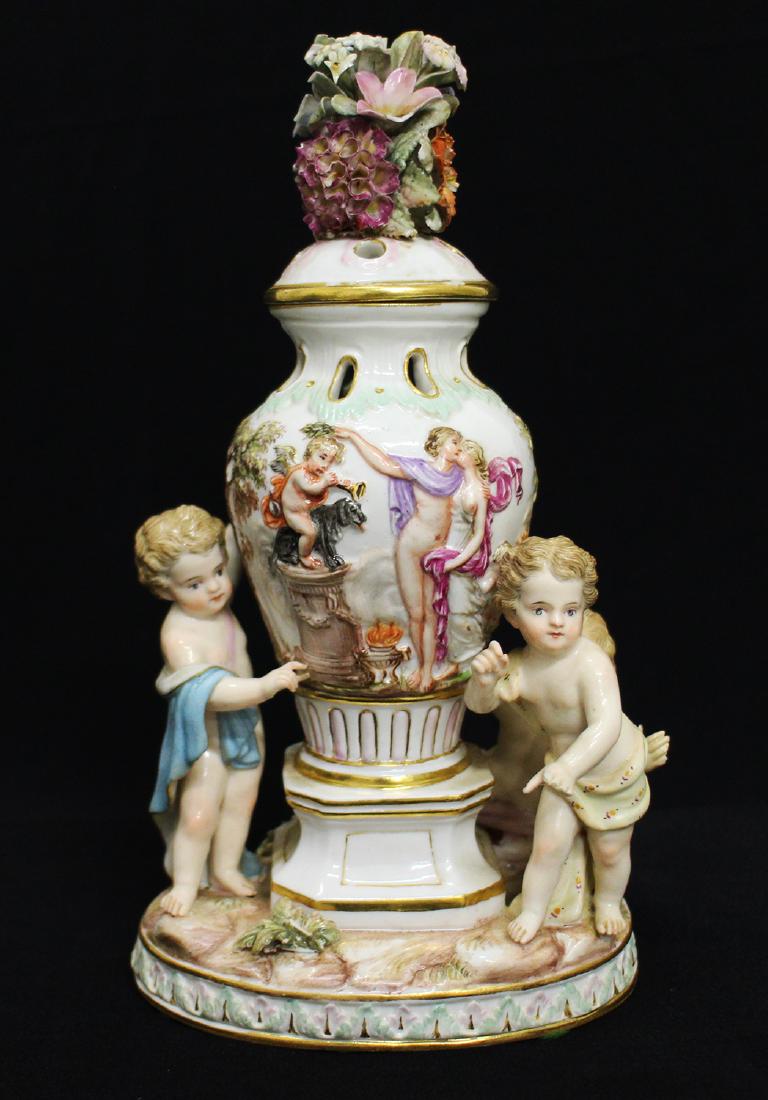 MEISSEN NEOCLASSICAL POTPOURRI URN: Meissen figural potpourri urn with three children surrounded center urn. Lid appears to be glued on, some small losses. 8.25" Tall. 1649 with blue crossed swords on bottom.