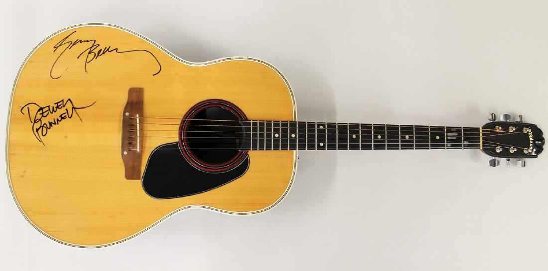 AMERICA AUTOGRAPHED ACOUSTIC GUITAR: America signed Applause acoustic guitar with signatures from Dewey Bunnell and Gerry Beckley. Guitar 41" long. Provenance: From the collection of the former executive director of several well known th
