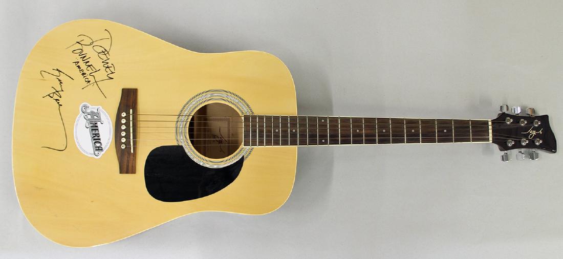 AMERICA AUTOGRAPHED ACOUSTIC GUITAR: America signed acoustic guitar with signatures from Dewey Bunnell and Gerry Beckley. Guitar 41" long. Provenance: From the collection of the former executive director of several well known theaters.