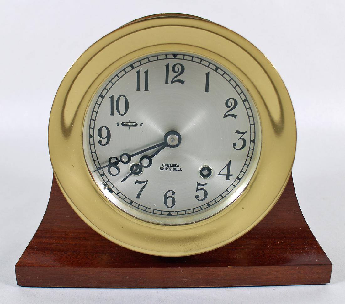CHELSEA SHIP'S BELL CLOCK: Chelsea ship's bell clock with wood stand. Includes key. Clock measures 5.5" wide.