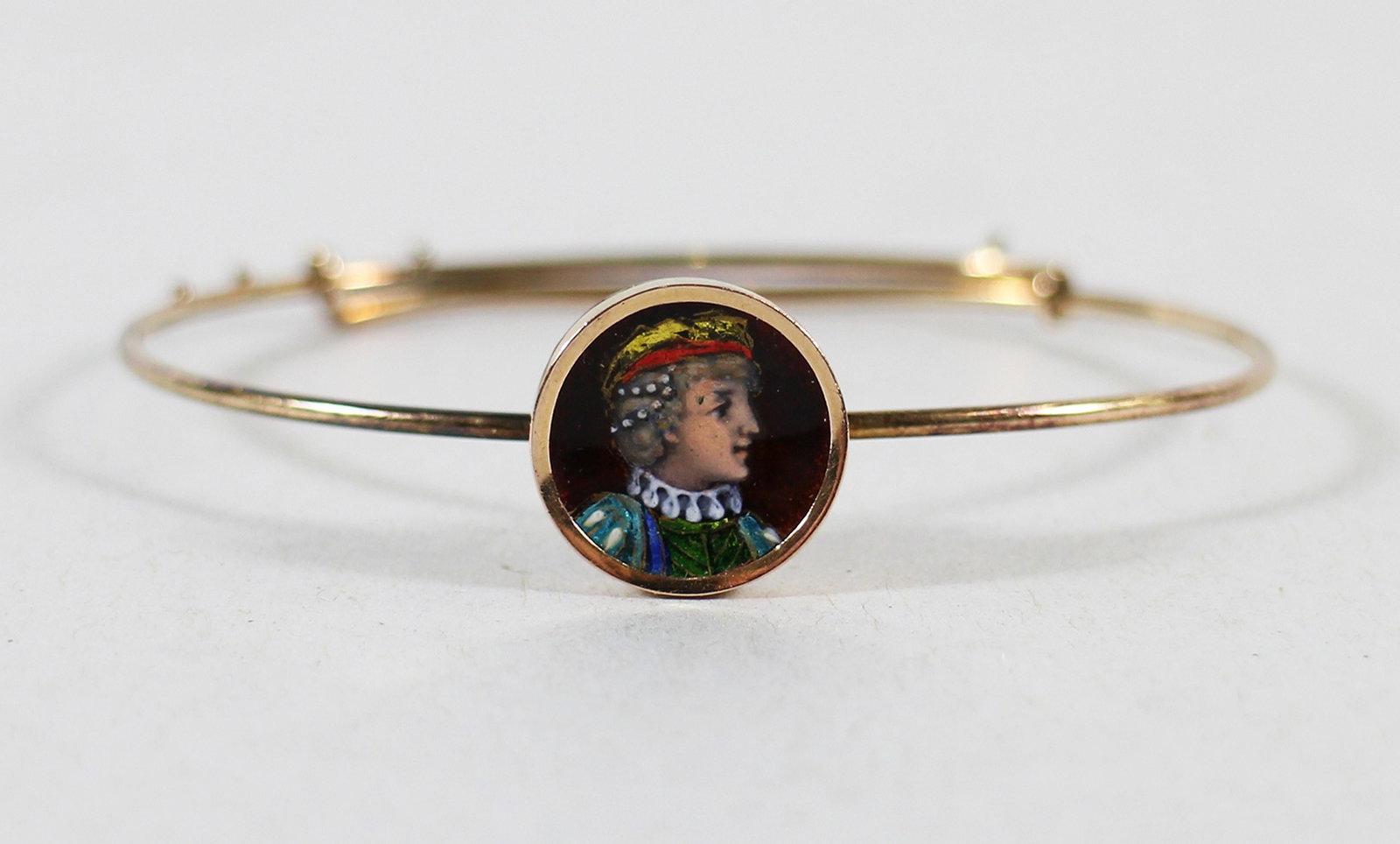 EDWARDIAN 14K GOLD ENAMEL PORTRAIT BRACELET: Antique14KT yellow gold bracelet with an enamel portrait of a noble man. The bracelet has notches and is adjustable.