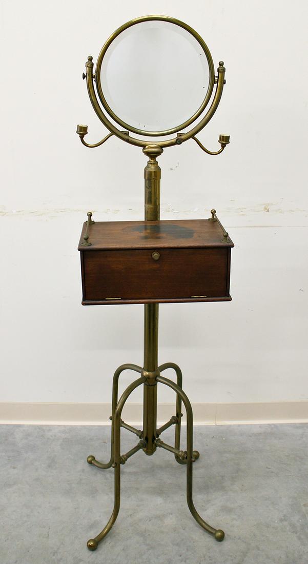 ANTIQUE STANDING BARBER SHAVING STAND: Brass & wood standing barber shaving stand with mirror and drop front storage box. Measures 61" tall 15" wide.