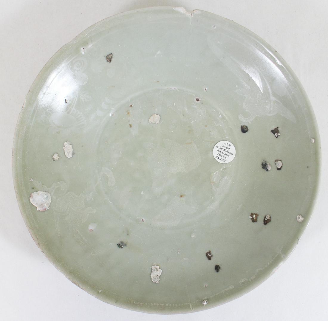 17TH CENTURY CHINESE MING CARGO CELADON DISH: Ming porcelain cargo of a Chinese trading vessel which sank circa 1640. It was discovered and salvaged by Captain Michael Hatcher in 1893 outside Malaysia in the South China sea. Measures 12.25" wide.
