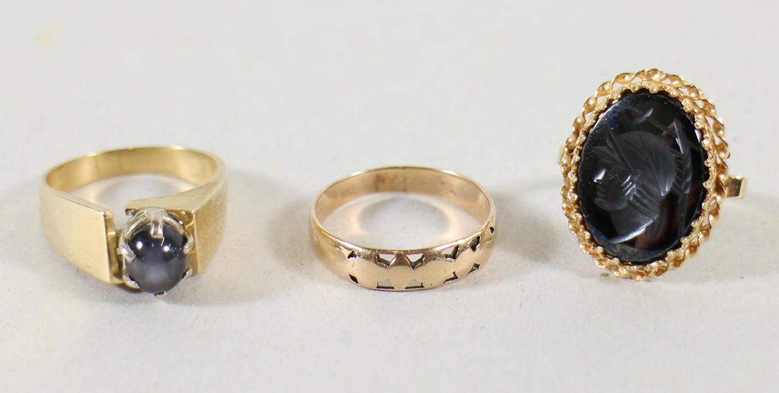 (3) 14-18K GOLD MEN's RINGS: A 14KT star sapphire ring size 11 (small hairline on band, doesn't affect ring), 14KT custom intaglio ring size 8, and an 18KT band size 11. Total weight 13 DWT.